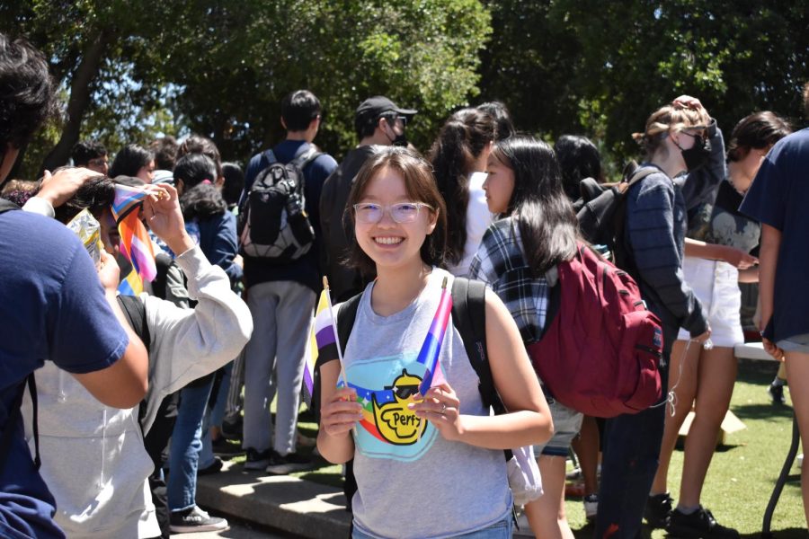 Freshman Aminjin Battulga holds a Pride flag in each hand
as she poses for a picture during Pride event activities.