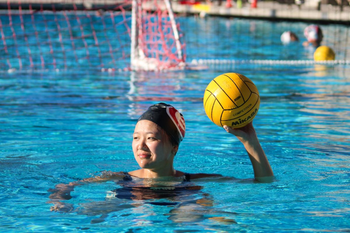 Senior Ellie Yuan holds the ball up to the goal to shoot.